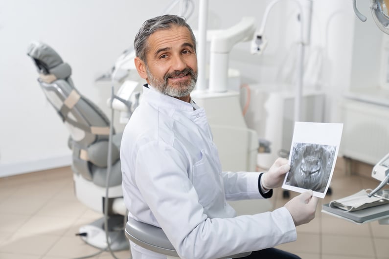 professional-dentist-posing-with-dental-x-ray-in-h-2023-11-27-04-54-33-utc-1