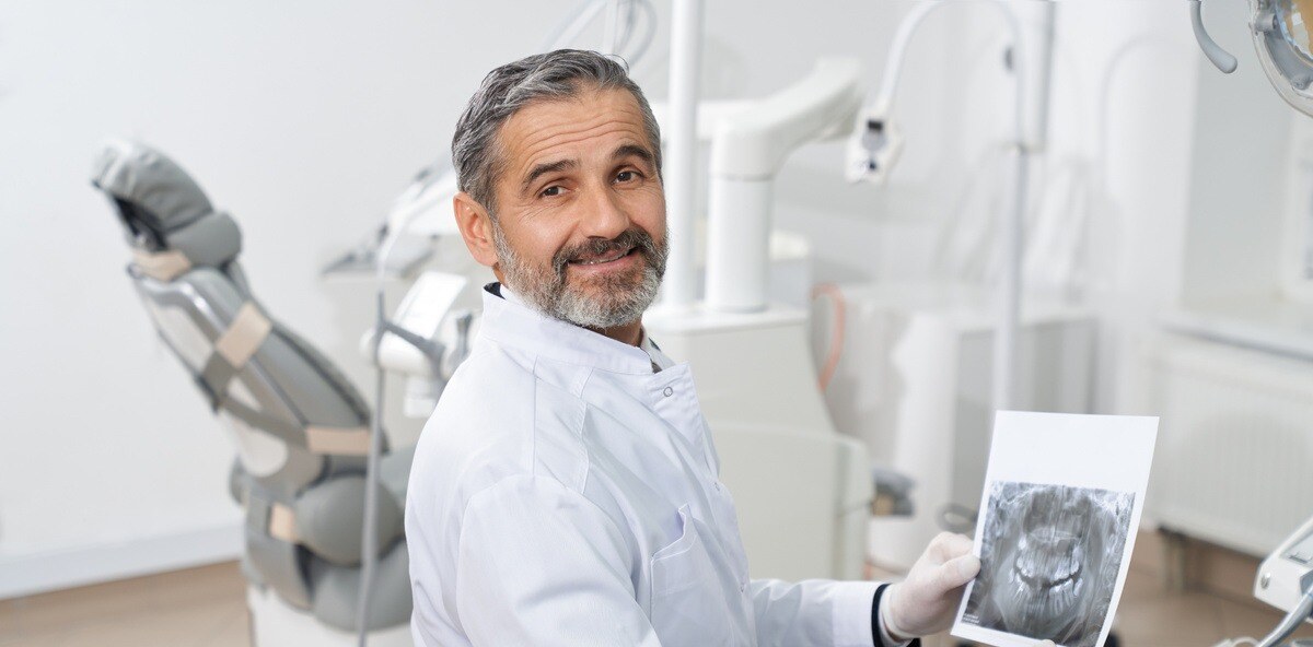 professional-dentist-posing-with-dental-x-ray-in-h-2023-11-27-04-54-33-utc-1-1